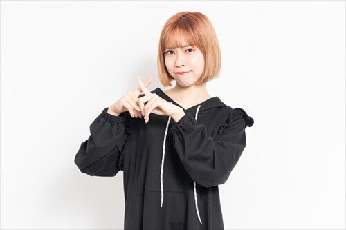 手でバツ印を作って注意を促す女性