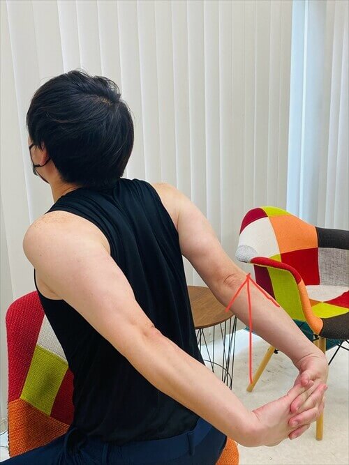 肩甲骨を寄せる姿勢をとる男性