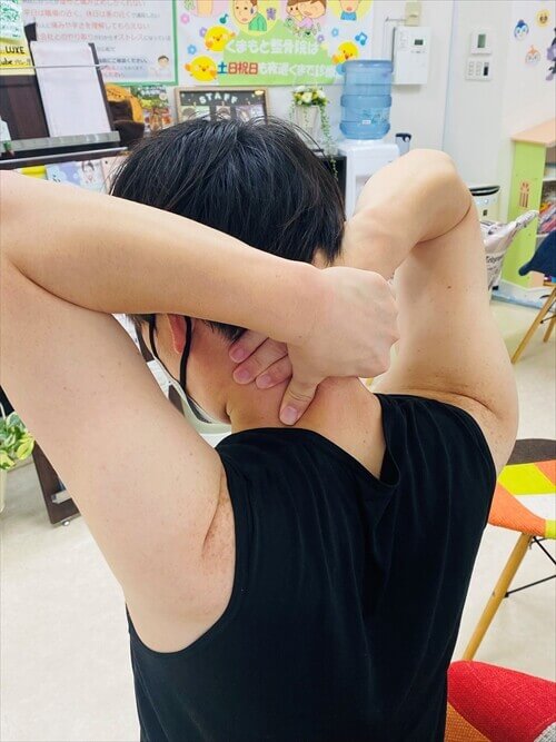 首の後ろの筋肉を両手でつまむセルフマッサージ